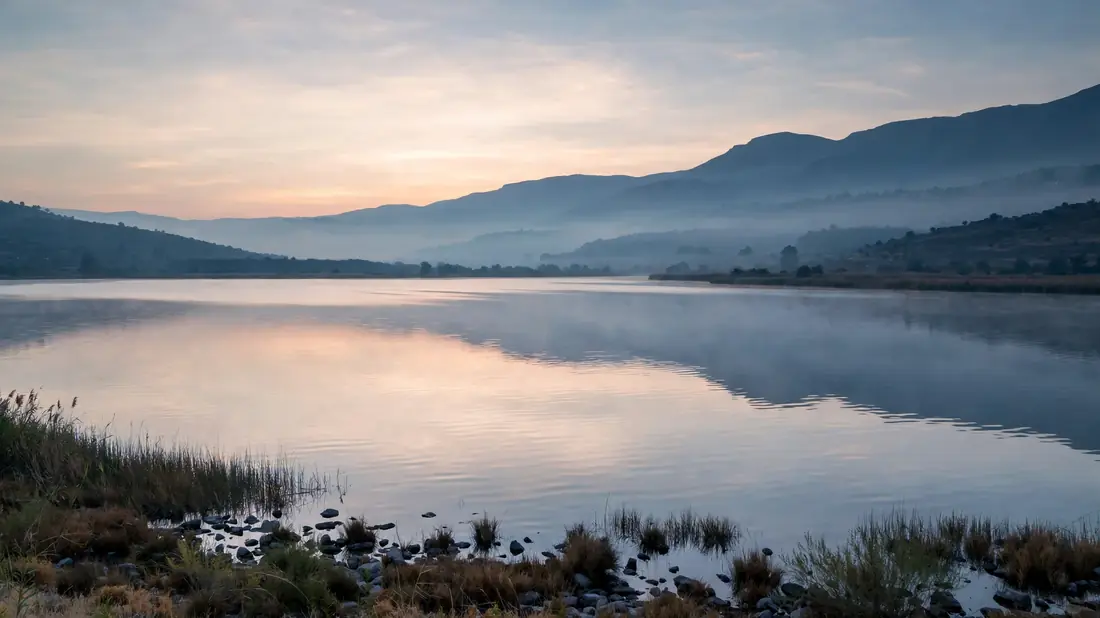 The calm waters of Lake Tiberias at dawn, mountains on the horizon