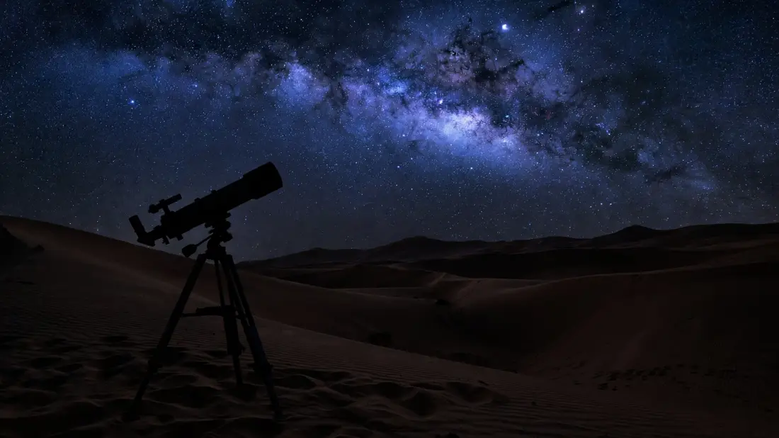 Telescope silhouette under the Milky Way in a desert night