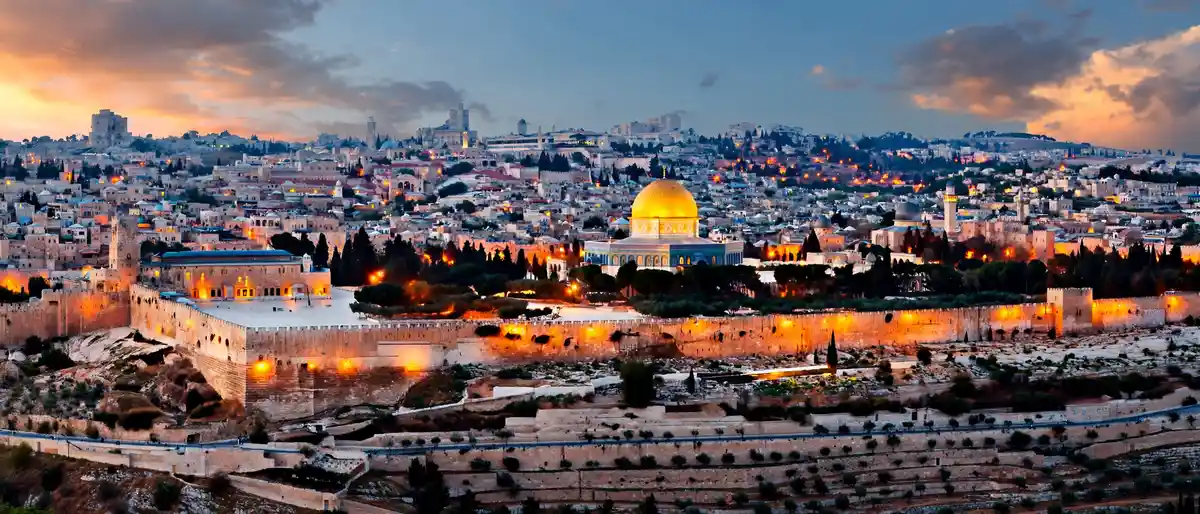 Panoramic view of Jerusalem's Old City skyline at dusk with the Dome of the Rock